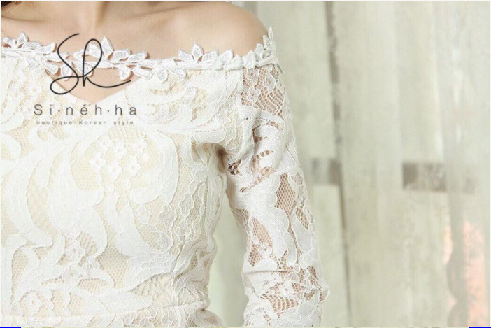 ชุดเดรสลูกไม้สีขาวอมครีม เปิดไหล่ ทรงเข้ารูป แขนยาว ชายกระโปรงแต่งระบาย แนวเรียบหรู สวยดูดี เหมาะสำหรับใส่เป็นชุดออกงาน ชุดไปงานแต่งงาน